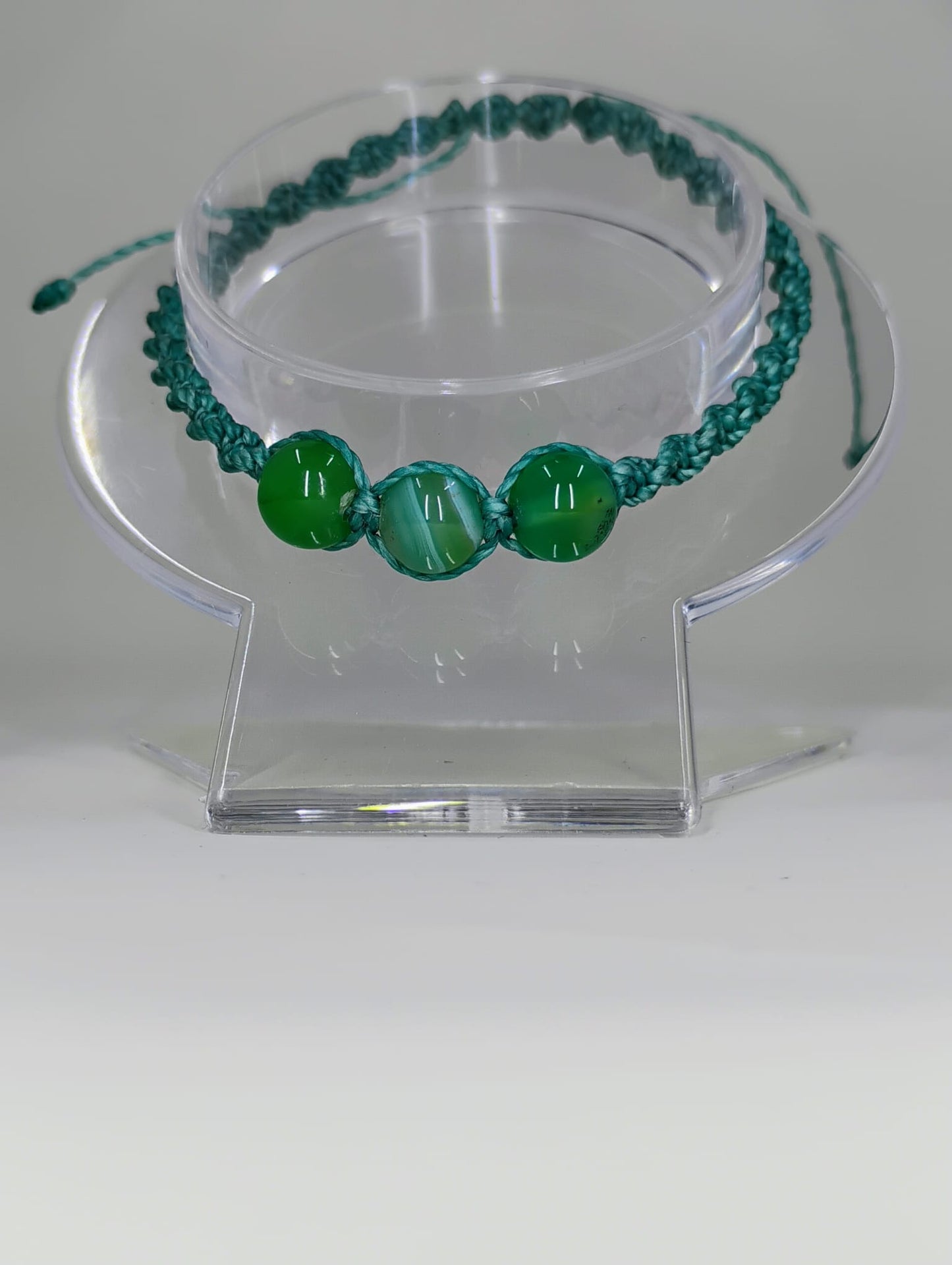 Hand-woven bracelet in green with crystal spheres.