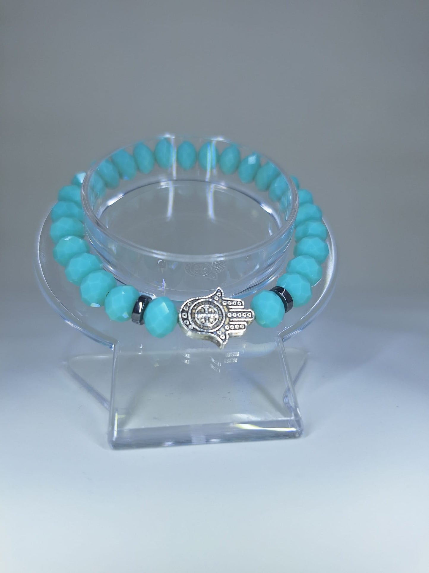 Cyan crystal bracelet, with Hamsa and St. Benedict Hand charm and flat separators.