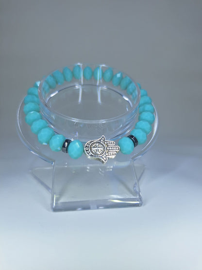 Cyan crystal bracelet, with Hamsa and St. Benedict Hand charm and flat separators.