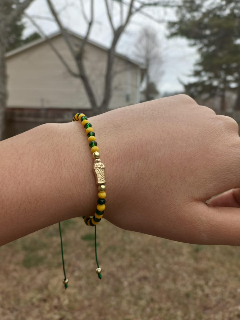 Hand-woven bracelet, with yellow and green beads, metal San Judas separator and golden beads.